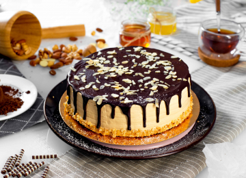 Торт «Сникерс»-шоколадный бисквит,пропитанный шоколадным сиропом,крем из сливок с варёной сгущенкой,мягкая карамель,арахис,покрытие темный шоколад,декорирован лепестками арахиса.